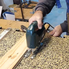 Op de foto wordt een WARCO-vloertegel in puzzelvorm met een decoupeerzaag bewerkt. Het flexibele materiaal is eenvoudig te bewerken met gangbaar gereedschap, zodat een exacte pasvorm mogelijk is. Zo kan de vloerbedekking perfect worden aangepast aan randen, hoeken en uitsparingen. De robuuste en elastische toplaag blijft onbeschadigd, wat een duurzame en onderhoudsvriendelijke oplossing garandeert.