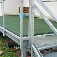 Les dalles de balcon WARCO en couleur vert gazon sont posées sur le caillebotis acier qui forme le sol du balcon.