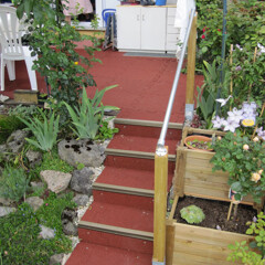 L'escalier extérieur recouvert de carreaux antidérapants de WARCO en couleur rouge brique mène du jardin à la terrasse.
