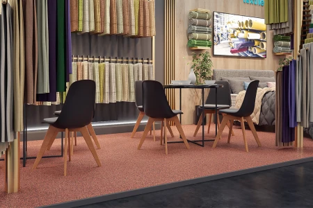Woningtextiel wordt gepresenteerd op een elegante beursstand. De in kleur afgestemde vloerbedekking bestaat uit voegvriendelijke kliktegels voor beursvloeren van gelijmd rubbergranulaat.