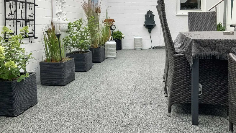 La terrasse accueillante aux tons clairs et foncés de gris a été rénovée à l'aide de carrelage WARCO en couleur Granit clair, avec une fermeture stable en forme de puzzle.