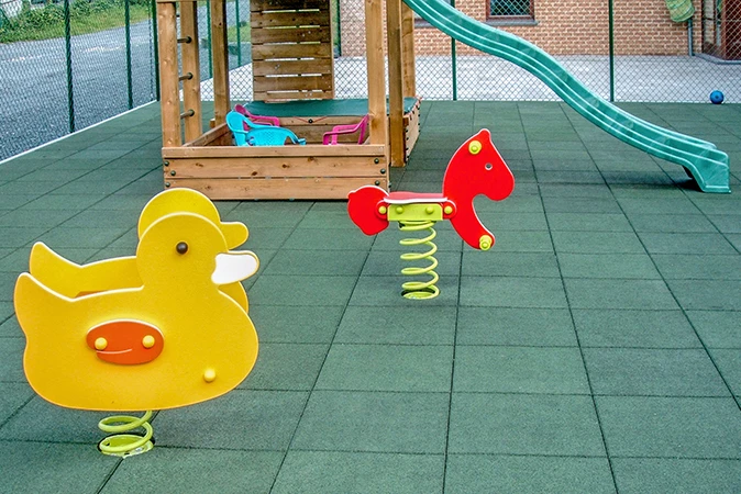 Fallschutzmatten outdoor aus Gummigranulat auf einem Spielplatz.