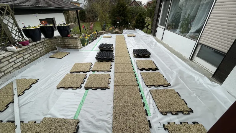 Sur une terrasse de jardin, les dalles WARCO dans la couleur Travertin sont posées directement sur une membrane imperméable d’EPDM avec une légère pente pour l'écoulement de l'eau.