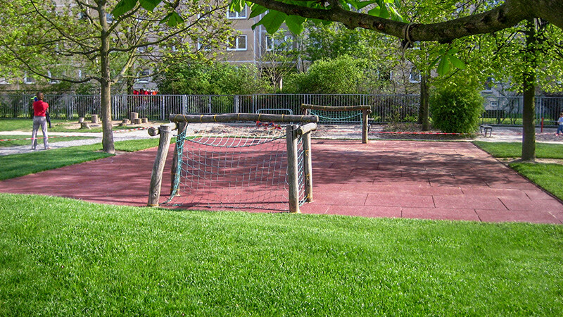 Le terrain de sport public dans le parc municipal avec deux filets pour un match de foot et le sol sportif rouge de WARCO.