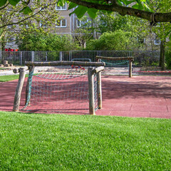 Le terrain de sport public dans le parc municipal avec deux filets pour un match de foot et le sol sportif rouge de WARCO.