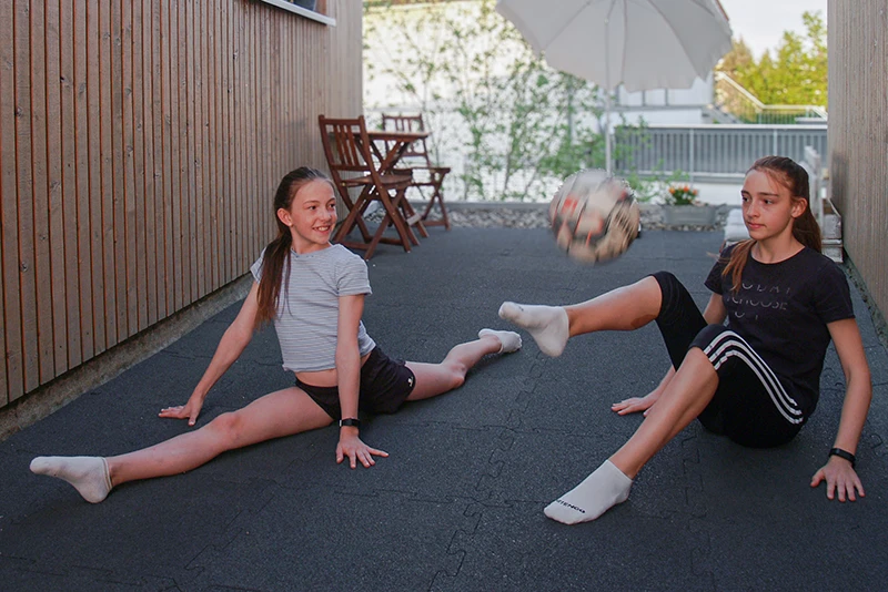 Kinder auf einem elastischen WARCO Bodenbelag im Außenbereich. Der Bodenbelag eignet sich für Fitness, Spiel, Freizeit und viele weitere Anwendungen im Innen- und Außenbereich.