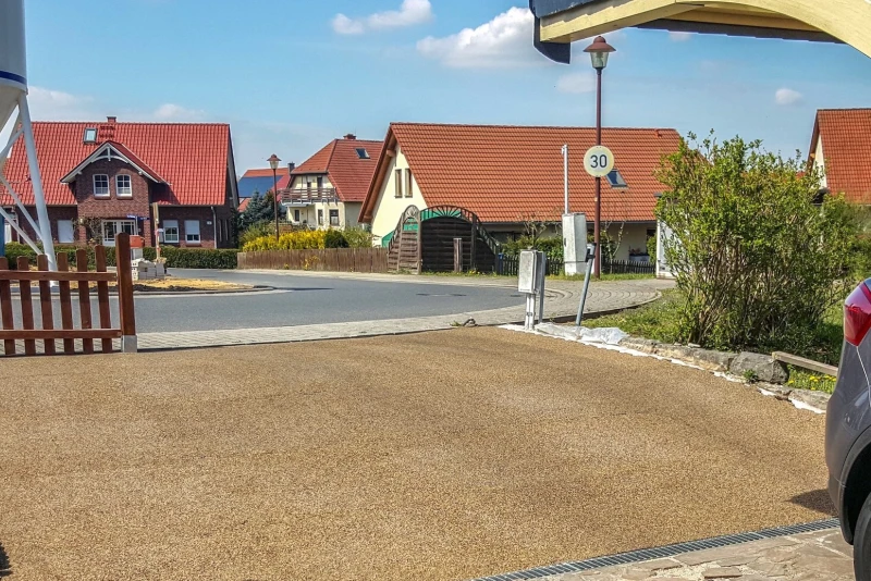 Un accès au garage du côté de la rue créé de dalles de trottoir Pro WARCO en couleur Terre cuite qui s'adaptent bien au terrain même s'il est incliné.