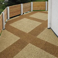 Op de foto zie je een ruim terras met twee kleurvarianten van de WARCO-vloerplaten. Een decoratief patroon in licht- en donkerbruin loopt over het hele oppervlak. De omringende houten balustrade zorgt voor privacy en sluit aan bij de natuurlijke uitstraling van de vloer. Dankzij de antislip- en weerbestendige eigenschappen is deze vloer ideaal voor buitenruimtes en creëert hij een uitnodigende sfeer. Hij is bovendien eenvoudig te reinigen en te leggen. Met weinig onderhoud blijft het een praktische en duurzame keuze.