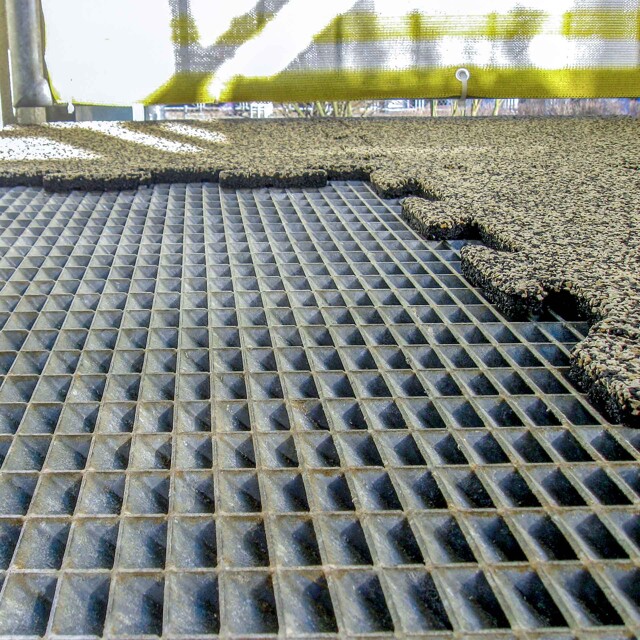 Auf einem Gitterrost, der den Boden eines Balkons bildet, werden 18 mm dicke Balkonplatten BZ von WARCO als neuer Balkonboden verlegt.