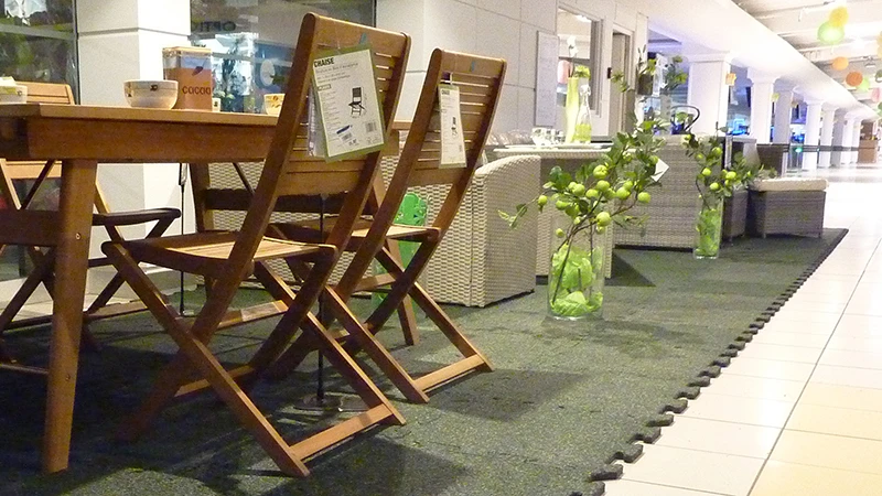 In het winkelcentrum was een deel van de betegelde laan afgezet voor de speciale verkoop van tuinmeubelen. De tuinmeubelen staan op groene kliktegels van de beursvloer.